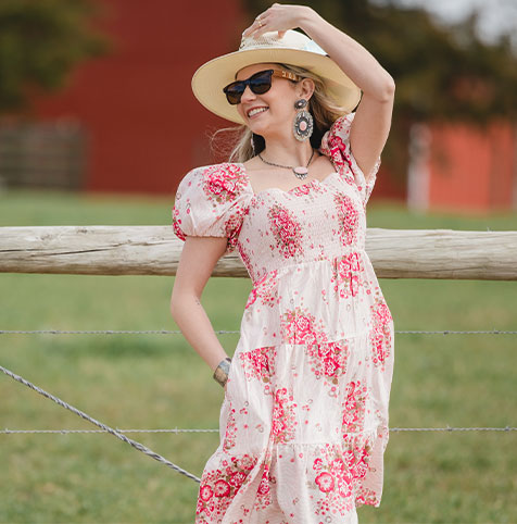 sam in floral dress with straw hat sunglasses and jewelry